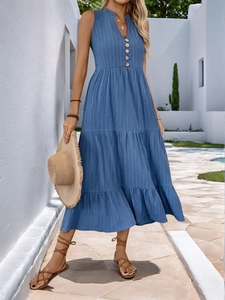 Detail of blue V-neck tiered vacation dress with wood-textured buttons and pleated fabric