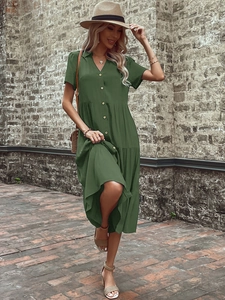 Detail of dark green lapel tiered dress featuring wooden buttons and pleated texture fabric
