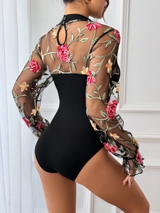 Detail of sheer mesh back with colorful rose floral embroidery on black bodysuit