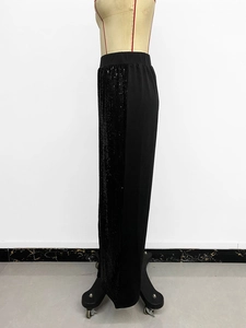 Detail of high waisted pants showing black sequin patchwork and elastic waistband