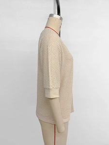 Détail de la texture en maille gaufrée beige sur un haut décontracté à demi-manches