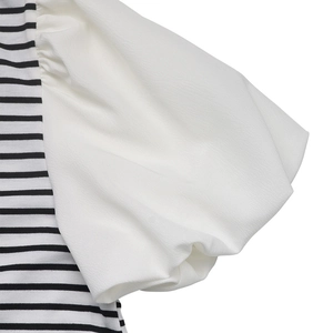 Detailed view of the puff sleeve attachment and black and white striped knit fabric