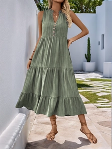 Detail of V-neck sleeveless grass green midi dress with wooden buttons and tiered skirt