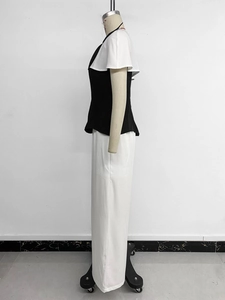 Détail de l'ensemble deux pièces avec haut noir à volants blancs et pantalon blanc chic