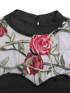 Detail of floral rose embroidery on black sheer mesh and heart-shaped neckline