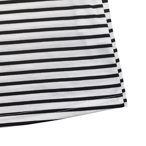 Detailed close-up of double-needle hem stitching on black and white striped knit top