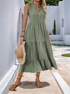 Detail of vintage green V-neck dress with textured fabric and tiered ruffle skirt