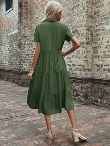 Outdoor shot of a dark olive green tiered midi dress with lapel collar and short sleeves