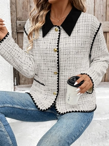 Close-up of tweed jacket texture with golden buttons and contrasting black trim details