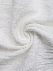 Macro shot of white textured seersucker fabric showing detailed crinkle patterns