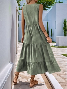 Back view of a sage green sleeveless tiered maxi dress with pleated texture on a woman