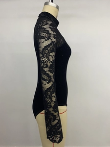 Detail of floral lace sleeves and sequin velvet fabric on black high-neck bodysuit