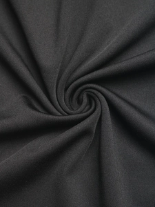 Detailed view of black knitted fabric with fine ribbed texture and subtle natural luster