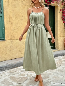 Detail of sage green maxi dress with pleats, high waist tie, and natural A-line silhouette