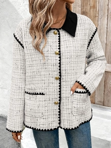 Detail of tweed jacket texture with golden buttons and contrasting black trim accents