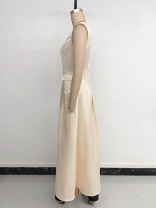 Detail view of champagne sleeveless satin dress with high waist and pleated skirt