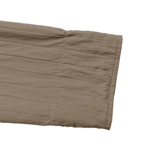 Macro shot of brown textured sleeve cuffs with horizontal quilting and vertical stitching