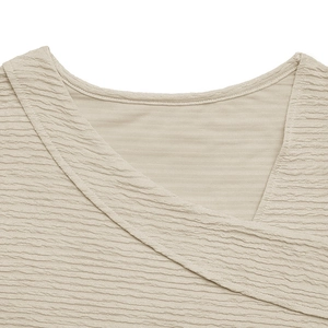Detail shot of the V-neckline showing the textured seersucker fabric on a beige top