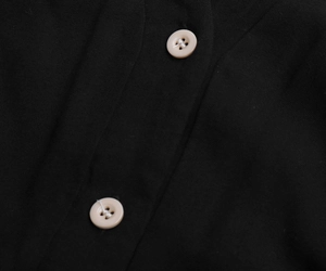 Macro shot of beige buttons on black cotton linen fabric for this summer dress