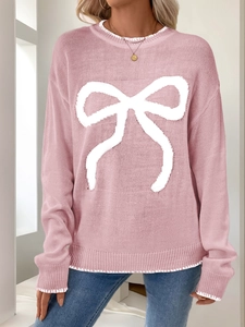 Close-up of pink knit sweater featuring a white fuzzy bow and decorative white stitching