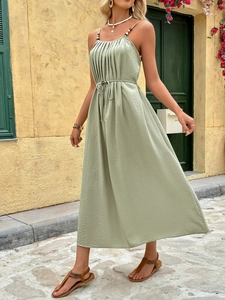 Detail of sage green maxi dress with beaded straps and pleated texture for summer vacation