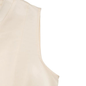 Detailed close-up of cream sleeveless dress featuring satin fabric texture and fine stitching