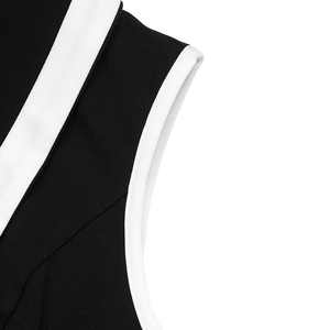 Detail shot of black knitted sleeveless dress featuring white contrast piping and neat stitching
