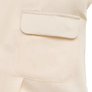 Detailed close-up of the elegant cream summer dress showing a pocket flap and stitching