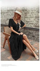 Dettaglio del vestito lungo nero con scollo a V, bottoni bianchi e vita elastica