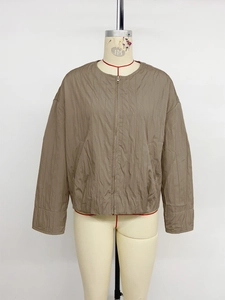 Macro detail of vertical quilted texture and zipper on the khaki brown casual jacket