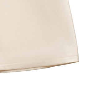 Macro shot of the smooth cream satin fabric edge and high-quality hem stitching