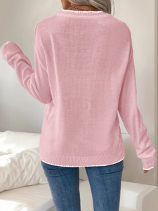 Detail view of pink knit sweater back with white stitching and ribbed texture
