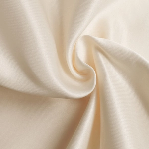 Detail of elegant cream satin fabric showing smooth texture and soft silk-like luster