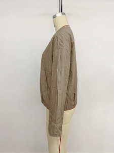Detailed side view of khaki casual zip jacket with textured quilted fabric on mannequin