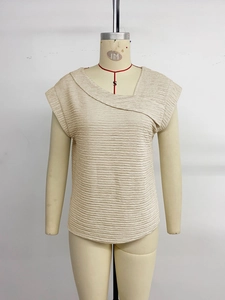 Detailed macro shot of beige textured fabric and asymmetric draped neckline design