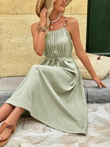 Macro detail of sage green summer dress showing pleats and adjustable spaghetti straps