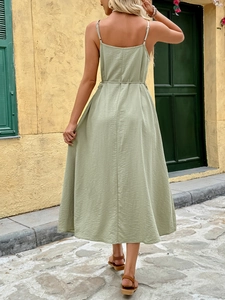 Detail of the back straps and waist belt on a green Mediterranean style summer dress