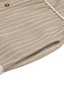 Detail of khaki striped dress showing wooden button, white lace trim and cotton fabric