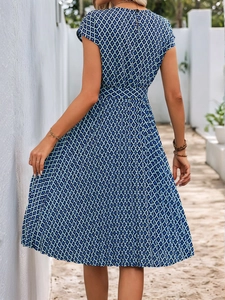 Elegant blue geometric print midi dress with cap sleeves and belted waist in natural light