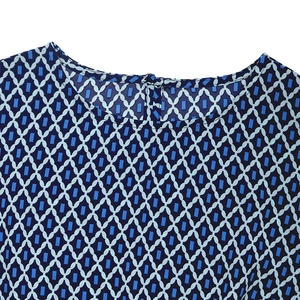Detailed view of the round neckline and back button closure on a blue geometric print dress