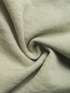 Detailed macro view of olive green linen fabric texture with natural weave and soft folds