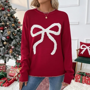 Christmas red knit sweater with white bow pattern in a festive holiday scene setup