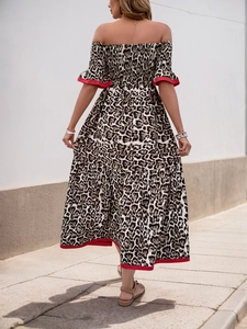 Detail of leopard print maxi dress featuring ruffled hem and striking red trim edges
