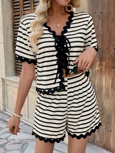 Close-up of black and white striped summer set with delicate scallop lace trim detail