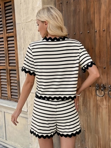 Detail of scalloped lace trim on striped short set featuring soft knitted fabric texture