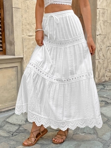 Détail d'une jupe longue blanche bohème avec broderie anglaise et volants en dentelle