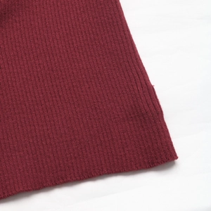Gros plan sur la texture du tricot côtelé rouge foncé montrant la qualité du tissage