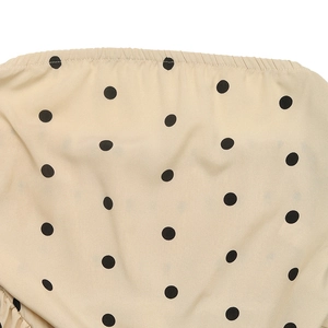 Dettaglio ravvicinato del tessuto beige a pois con texture arricciata elastica e trama