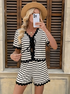 Detail of black and white striped two-piece set featuring lace trim and tie-front closure