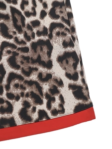 Macro detail of leopard print fabric with red contrast hem and premium stitching
